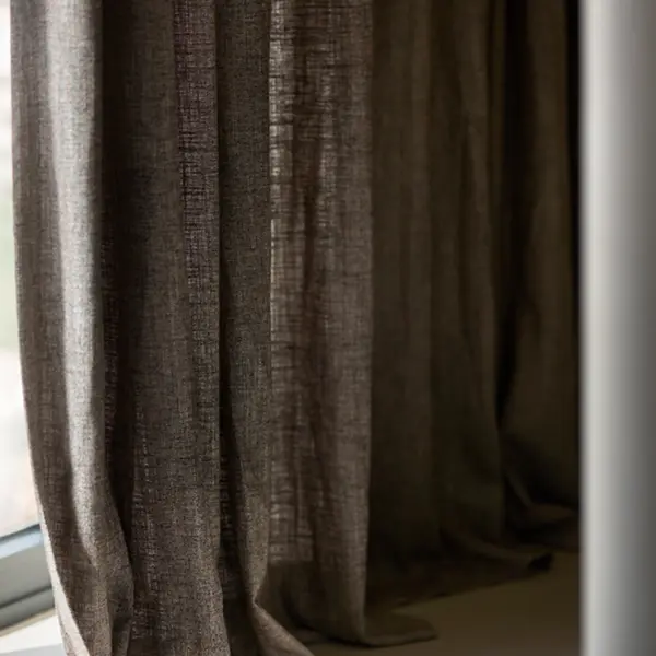 Century curtain fabric in a deep natural tone, made from 70% viscose and 30% linen, featuring a rich multi-flecked texture with subtle satiny sheen, closed-weave drapery shown in an elegant interior setting.