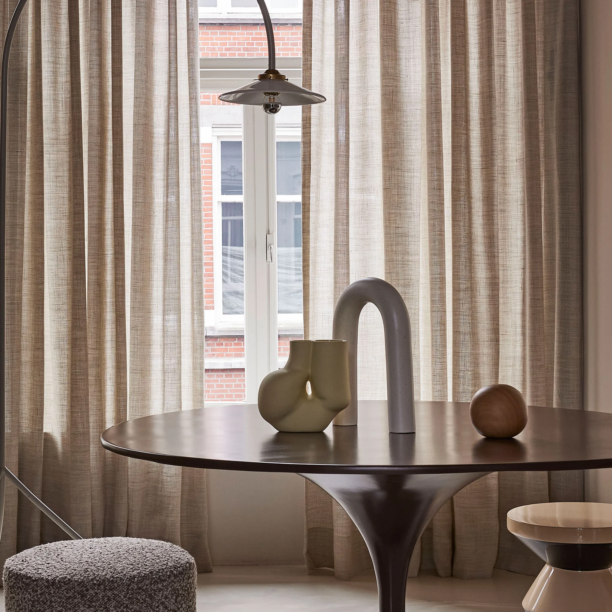 Dew sheer curtain fabric in a soft natural tone, made from 90% wool and 10% linen, shown as inbetween transparent drapery that gently filters daylight in an elegant interior, OEKOTEX certified.