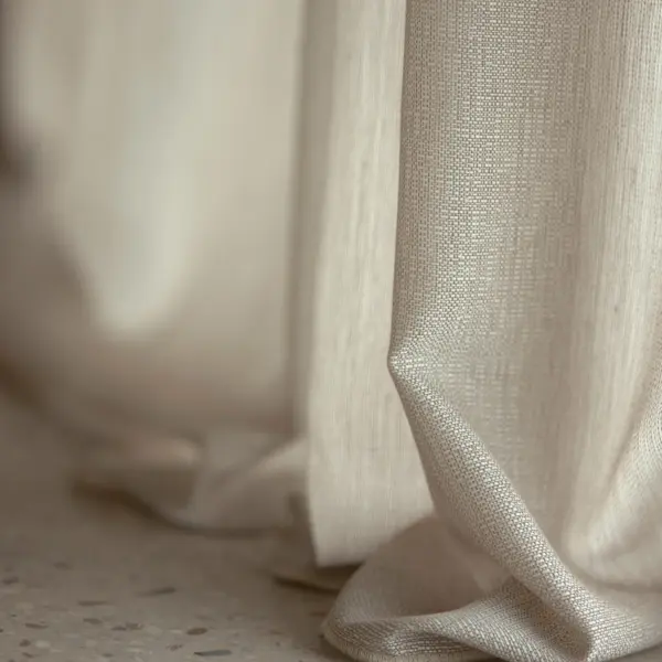 Flow in-between curtain fabric with soft satin-like sheen, made from 100% recycled Trevira CS polyester, shown in a close-up drape with subtle irregular weave, light-filtering transparency, room-high and flame-retardant, OEKOTEX certified.