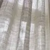 Gerst sheer curtain fabric close-up showing an inbetween transparent open weave, made from a blend of polyester, cotton, linen, and viscose, featuring a natural grid texture that softly filters daylight, OEKOTEX certified.