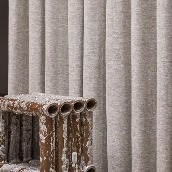 Iro curtain fabric with a closed weave texture, made from 50% recycled polyester and 50% cotton, shown as vertically pleated drapery in a neutral tone with soft natural texture, suitable for Roman blinds and OEKOTEX certified.