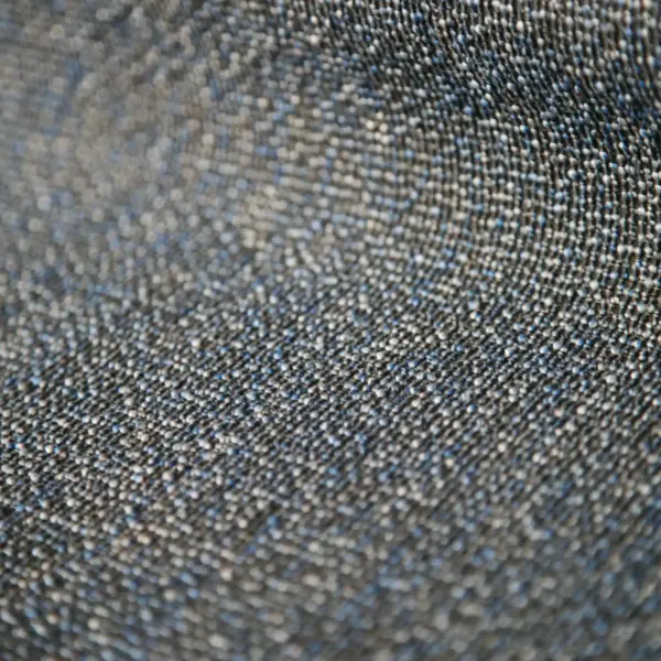 Reno upholstery fabric close-up with a sturdy woven structure and subtle melange color effect, made from a durable blend of polyester and cotton, featuring a three-dimensional texture created by contrasting warp and weft yarns, suitable for modern residential and commercial furniture interiors.